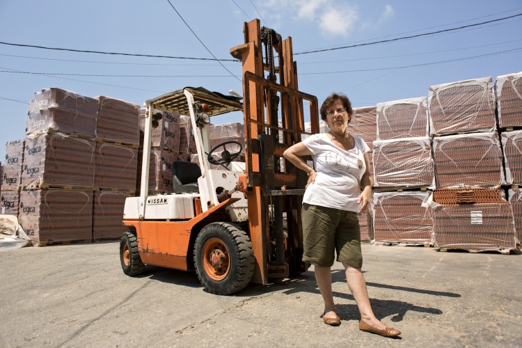Woman standing outside by a forklift
