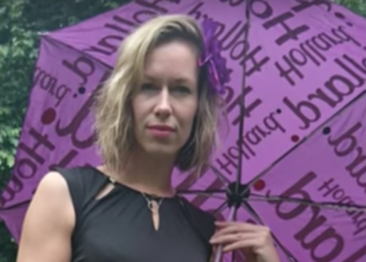 Lisa Foster holding a purple Hollard umbrella.