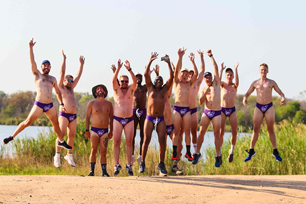 A group of Daredevil runners posing in speedos jumping in the air