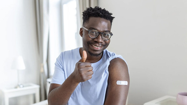 A prostate cancer survivor smiling with a thumbs up